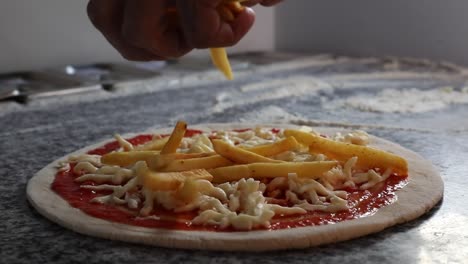 Un-Jefe-Pone-Patatas-Fritas-En-Una-Pizza-Italiana,-Primer-Plano,-Plano-Insertado