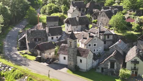 Small-village-with-stone-houses-and-a-bell-tower,-surrounded-by-greenery-in-Maggiatal-Vallemaggia,-Switzerland