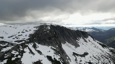 Dramatic-Rocky-Peak-with-Snow,-Moody-Sky