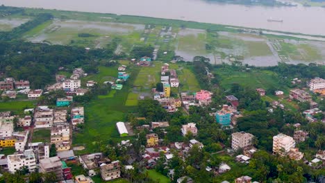 Urbanization-along-the-Kirtankhola-River-with-cargo-ships-in-view-at-Barisal-City,-Bangladesh