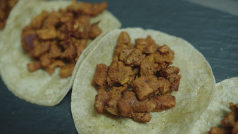 Bonita-Toma-En-Cámara-Superlenta-Y-Con-Un-ángulo-Entrecortado-De-Un-Conjunto-De-Tortillas-Mexicanas-Con-Carne-Dispuestas-En-Fila-En-La-Cocina-De-Un-Restaurante-Mexicano.