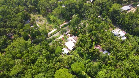 Remote-indigenous-village-deep-in-Amazon-dense-forest-canopy,-aerial-view