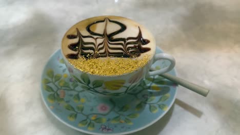 24-Karat-Goldflocken-Cappuccino:-Tasse-Kaffee-Mit-Arabischer-Kunst-Im-Schaum