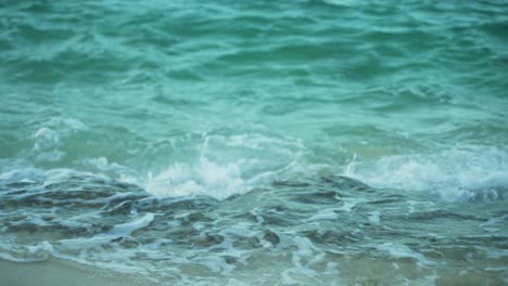 Closeup-shot-of-turquoise-sea-water-surf-coming-towards-beach