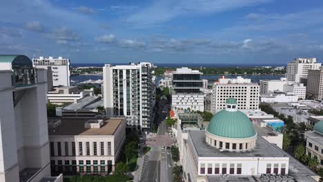 Drone-En-Ascenso-Del-Centro-De-West-Palm-Beach-Con-Arquitectura-De-Cúpula-Y-Océano-De-Fondo