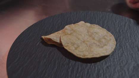 Beautiful-slow-motion-shot-of-a-chef-serving-shredded-chicken-inside-some-Mexican-tortillas-to-prepare-the-famous-dish-Mexican-enchiladas-in-green-sauce