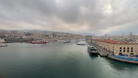 Drone-fly-above-Genoa,-Italy-port-and-old-town-during-a-cloudy-day-with-storm-approaching-the-city