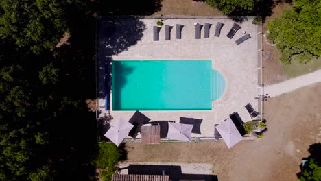 Top-down-shot-of-sun-loungers-sitting-around-the-private-pool