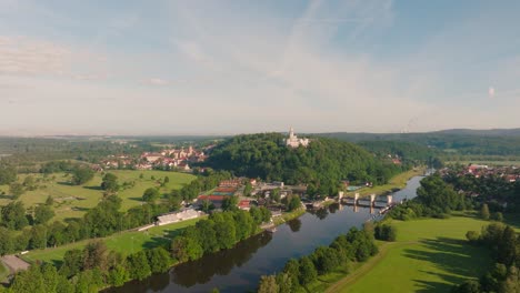 Imágenes-Aéreas-En-4K-Del-Castillo-De-Hluboka-Nad-Vltavou,-La-Ciudad,-El-Campo-De-Golf-Y-El-Río-Moldava-En-Chequia,-Europa