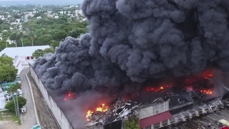 Luftaufnahme-Von-Feuerwehrleuten,-Die-Versuchen,-Die-Flammen-In-Einer-Fabrik-In-Santo-Domingo-Zu-Löschen