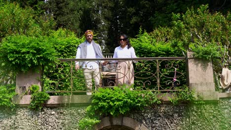 Happy-couple-with-dog-admires-beauty-of-green-gardens,-view-from-bellow