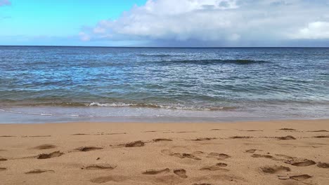 Olas-Rompiendo-En-Una-Playa-De-Arena-Con-Cielos-Azules-Y-Nubes-Ligeras-Tomadas-En-Maui,-Hawái