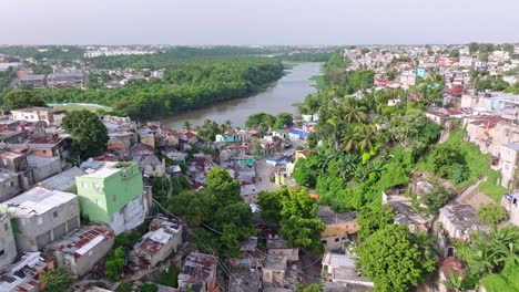 Scenic-aerial-atop-El-Capotillo-infamous-neighborhood-and-the-Rio-Isabela-in-Santo-Domingo,-Dominican-Republic