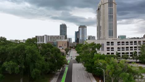 Aerial-forward-shot-of-main-street-in-downtown-of-Orlando-City-during-cloudy-day