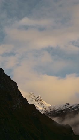 Fondo-De-Montañas-Escarpadas-Al-Atardecer-Con-Espacio-Para-Copiar-Texto,-Video-Vertical-De-Un-Espectacular-Paisaje-Montañoso-Escarpado-Y-Cubierto-De-Nieve-Entre-Hermosas-Nubes-Para-Redes-Sociales,-Instagram-Y-TikTok