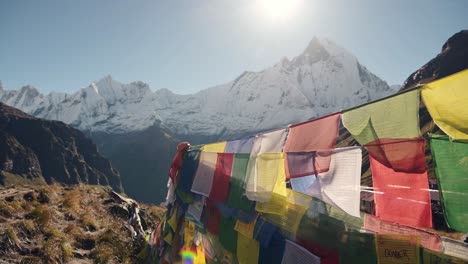 Prayer-Flags-in-Snowcapped-Mountains-in-Nepal,-Colorful-Tibetan-Buddhist-Prayer-Flags-on-Blue-Sky-Sunny-Day-in-the-Himalayas-in-Annapurna,-Colourful-Buddhism-Flags-in-Nature-with-Snowy-Mountains