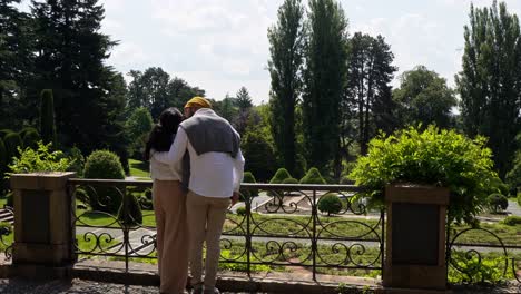 Young-lovers-admires-beauty-of-Italian-palace-gardens,-back-view