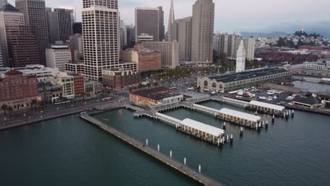 Una-Vista-Aérea-Tomada-Con-Un-Dron-Del-Ferry-Building-En-San-Francisco-Muestra-La-Icónica-Costa,-Donde-El-Espacio-Abierto-Del-Parque-Se-Encuentra-Con-El-Encanto-Histórico-Del-Ferry-Building-Y-La-Bulliciosa-Ciudad.