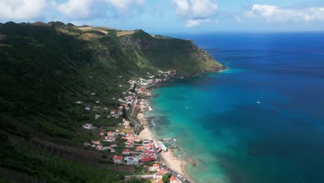 Praia-de-São-Lourenço-beach-and-houses-by-coastal-hills-in-Azores,-aerial-pan