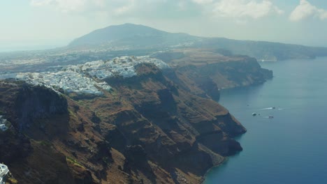 Aerial-view-of-Thira-in-Santorini-island-and-its-unique-architecture-of-whitewashed-houses-on-the-cliff