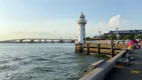 Una-Imagen-Fija-Del-Faro-En-El-Muelle-De-Raffles-Marina-Y-El-Segundo-Puente-De-Enlace-De-Tuas-Entre-Singapur-Y-Malasia-Durante-La-Puesta-De-Sol.