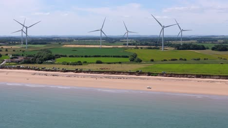 Drone-Aerial-footage-of-a-wind-turbine,-windmill-turning-in-the-wind-on-a-wind-farm-in-the-North-of-England-showing-renewable-energy-efficient-wind-power