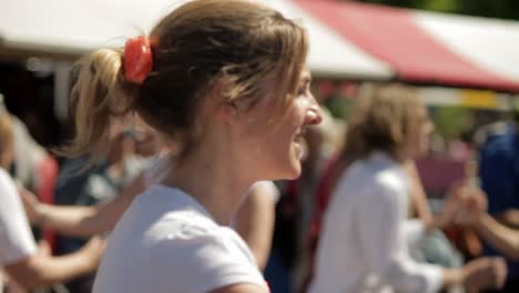 A-senior-man-and-a-young-woman-dance-salsa-together-in-an-open-air-group-dance-during-a-festival