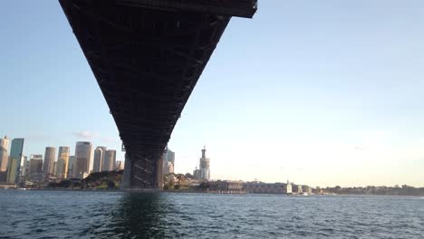 Wunderschönes-Schwenken-Und-Nahaufnahme-Der-Sydney-Harbour-Bridge-Unterhalb-Der-Brücke-Bei-Sonnenuntergang