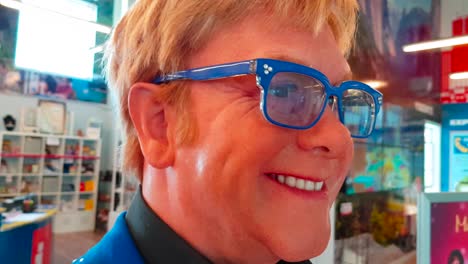 Close-up-gimbal-shot-of-wax-figure-of-musician-Elton-John-in-tourist-office-on-Pier-39-in-San-Francisco,-California,-USA