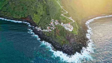 Aerial-orbiting-shot-of-Arnel-Lighthouse-on-scenic-promontory-by-Atlantic-Ocean,-Azores