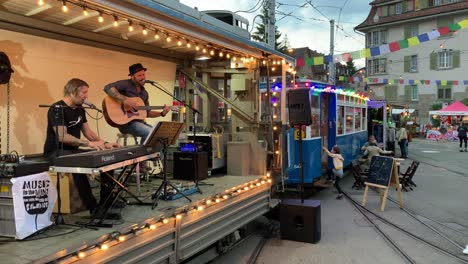 Musiker-Spielen-Musik-In-Einem-Alten-Straßenbahnwagen-Auf-Der-Sommermesse-Neben-Dem-Straßenbahnmuseum-In-Zürich,-Schweiz