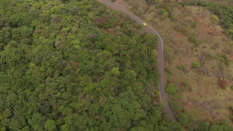 Vista-Aérea-Tomada-Con-Dron-Sobre-Una-Carretera-Boscosa-En-Una-Colina