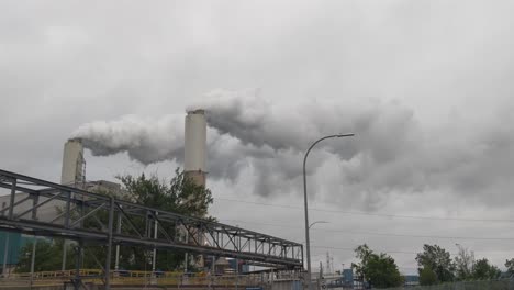 Coal-fired-electrical-plant,-steam,-smoke,-pollution-rising-from-twin-stacks,-power-generation,-clean-coal