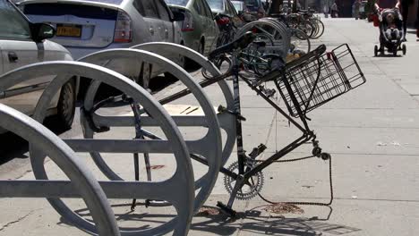 Abandoned-bicycle-frame-locked-to-bike-rack-with-stolen-wheels