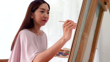 Woman-female-artist-painting-picture-on-canvas-with-oil-paints-at-my-home-as-her-hobby