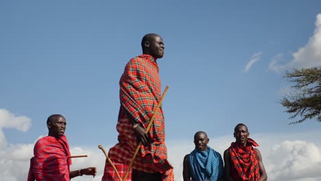 Es-Un-Espectáculo-Maravilloso-Ver-A-Los-Guerreros-De-La-Tribu-Masai-Realizar-Su-Danza-Del-Salto-Y-Saltar-En-Lo-Alto-Del-Aire-Frente-A-Su-Aldea-En-Masai-Mara,-Kenia.