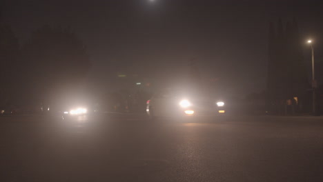 Cars-driving-at-night-through-a-neighborhood