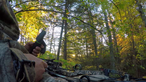 Camouflaged-hunter-with-bow-waiting-for-animals-in-wilderness,-close-up-wide-FOV