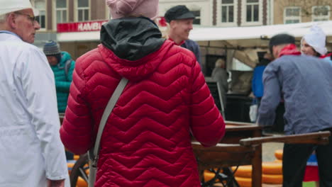 Traditioneller-Holländischer-Marktplatz-Mit-Ausländischen-Touristen,-Die-Fotos-Von-Männern-Machen,-Die-Käse-Auf-Einen-Wagen-Laden