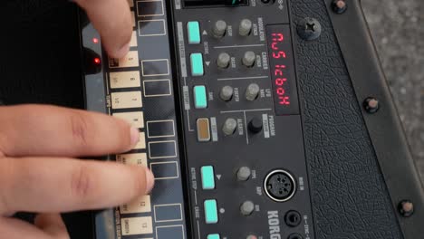 Top-view-of-a-girl-playing-analogue-electronic-musical-loop-synth-instrument-on-open-air-concert