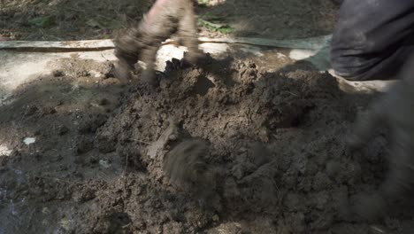 A-man-knead-clay-on-the-ground---close-up-shot