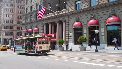 Cable-Car-passing-by-Union-Square-and-stopping-for-passengers-in-San-Francisco,-California,-United-States