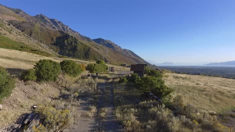 Eine-Drohne-Fliegt-über-Den-Feldweg-Eines-Pferdehofs-In-Den-Ausläufern-Der-Alpine-Mountains-In-Utah