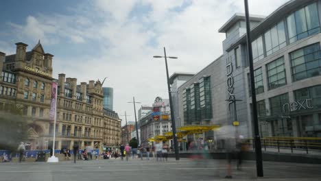 Time-lapse-Con-Imprentas-A-Lo-Lejos-Cerca-Del-Centro-Comercial-Arndale,-Manchester-City,-Con-Gente-Cruzando-En-La-Toma,-Día-Soleado,-Atracción-Turística,-Punto-De-Referencia,-4k-25p