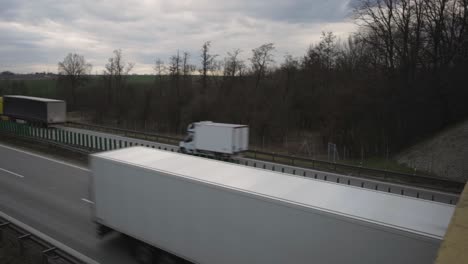 Oben-Blick-Auf-Eine-Viel-Befahrene-Autobahn-Mit-Vorbeirasenden-Lastwagen-Und-Autos