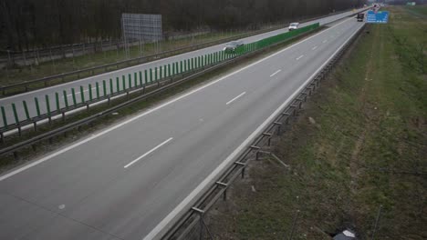 Vehicles-Travelling-On-The-Long-And-Winding-Road-In-Poland-At-Daytime---high-angle-shot