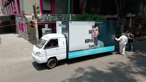 Wide-angle-static-shot-of-people-gathering-at-marketing-truck-at-roadshow