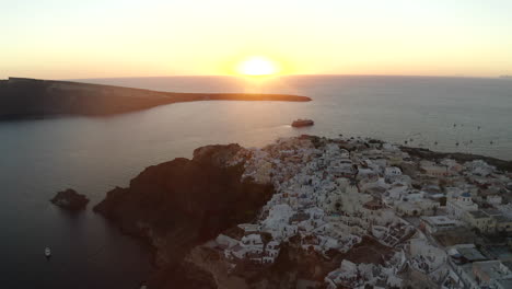 Oia-Santorini-Insel-Sonnenuntergang-Drohne-Mit-Blick-Auf-Weiße-Gebäude-Und-Das-Meer,-Griechenland-In-4k