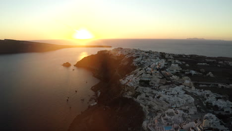 Oia-Santorini-Insel-Sonnenuntergang-Drohne-Mit-Blick-Auf-Weiße-Gebäude-Und-Das-Meer,-Griechenland-In-4k