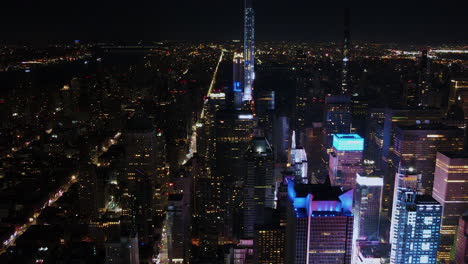 Vibrant-Skyscrapers'-Light,-aerial-sliding-shoot-of-New-York-City,-with-colorful-activity-at-night-showing-the-avenues-and-the-tallest-buildings-from-the-sky